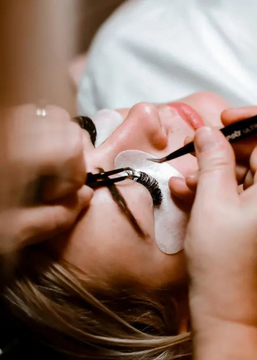 woman applying eyelash extensions